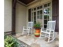 Cozy front porch featuring two rocking chairs and stone flooring, perfect for enjoying the outdoors at 1103 Mapesbury Ln, Waxhaw, NC 28173