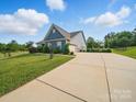 Long driveway leads to a well-maintained home with verdant landscaping and a garage at 11225 Island View Ln, Lancaster, SC 29720