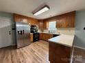 Well-lit kitchen with stainless steel appliances, ample counter space, and wood cabinets for efficient cooking at 117 Lincoln Village Dr, Statesville, NC 28677