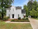 Well-maintained home showcasing its landscaped front yard, driveway, and a detached garage on a sunny day at 124 Creek Hollow Trl, Belmont, NC 28012