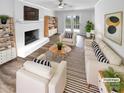 Bright living room with a white-painted brick fireplace, ceiling fan, and neutral-toned furniture arrangement at 124 Creek Hollow Trl, Belmont, NC 28012