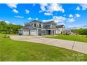 Charming blue home with a three-car garage, green lawn, and inviting front porch at 126 Still Creek Dr, Mooresville, NC 28115