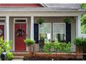 Inviting front porch with tasteful decor, including hanging plants and charming seating area at 12663 Windyedge Rd, Huntersville, NC 28078