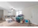 Bright living room with neutral walls, ceiling fan, large sectional sofa, and lots of natural light at 1316 Wiscassett St, Albemarle, NC 28001