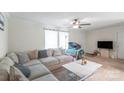 Bright and open living room with neutral walls, ceiling fan, large sectional sofa, and lots of natural light at 1316 Wiscassett St, Albemarle, NC 28001