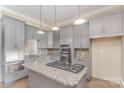 Modern kitchen features stainless steel appliances, granite counters, tiled backsplash, and gray cabinets at 135 Waycross Dr, Rockwell, NC 28110
