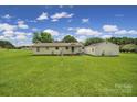 Large backyard featuring a well-kept lawn, ideal for outdoor activities, with an exterior view of the house at 2084 Old Evans Cir, Lancaster, SC 29720