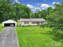 Lovely single-story home with a detached garage and a spacious front lawn, surrounded by mature trees at 2084 Old Evans Cir, Lancaster, SC 29720