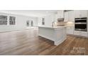 Modern kitchen featuring an island, stainless steel appliances, white cabinetry, and light wood flooring at 21063 Running Creek Dr # 11, Locust, NC 28097