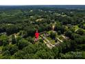 Aerial view showcases this home in a lush, wooded neighborhood with mature trees at 2209 Cardinal Loop, Stanley, NC 28164