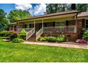 Charming brick house has a covered front porch with white railing and comfortable seating area at 2209 Cardinal Loop, Stanley, NC 28164