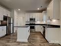 Modern kitchen featuring stainless steel appliances, white cabinetry, an island and dark countertops at 231 Brook Se Ave, Concord, NC 28025