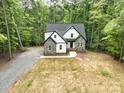 Exterior view of the home featuring its gray roof, stone and siding combination, and landscaped front yard at 248 Pioneer Dr, Mount Gilead, NC 27306