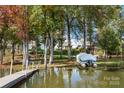 Picturesque waterfront featuring a covered boat, dock, and lush trees at 25566 Seagull Dr, Lancaster, SC 29720
