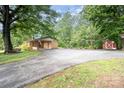 A long driveway leads to a lovely brick home with an American flag and mature trees at 2631 Ivey Church Rd, Lincolnton, NC 28092