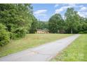 A beautiful, long driveway leads to a charming brick home surrounded by lush trees at 2631 Ivey Church Rd, Lincolnton, NC 28092