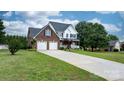 Beautifully landscaped home featuring a lush lawn, mature trees, and a long driveway at 2779 Touchstone Cir, Newton, NC 28658