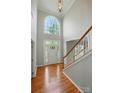 Bright foyer featuring hardwood floors, a staircase with white railings, and a large arched window above the front door at 415 Glandon Ct, Fort Mill, SC 29708