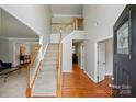 Open foyer with hardwood floors, staircase with carpet runner, and doorways leading to other rooms at 415 Glandon Ct, Fort Mill, SC 29708