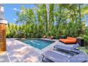 Secluded backyard pool area with lounge seating surrounded by lush greenery at 4211 Tangle Dr, Charlotte, NC 28211