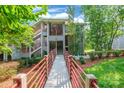 Inviting condo exterior with red railings, lush greenery, and convenient walkway access at 502 Lake Club Dr, Rock Hill, SC 29732