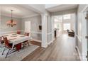 Elegant dining room with modern light fixture, hardwood floors, and seamless transition to the living area at 537 Montgrove Nw Pl, Concord, NC 28027