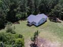 Single-story home with a gray roof, surrounded by lush trees and a well-maintained green lawn at 5410 A R Gordon Rd, Waxhaw, NC 28173