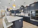 Modern kitchen with blue cabinets, stainless steel appliances, marble backsplash, and gold accents at 6015 Waldorf Ave, Monroe, NC 28110