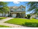 Beautiful two-story home featuring stone details, a manicured lawn, and a cozy covered entryway at 6333 Cory Bret Ln, Charlotte, NC 28278
