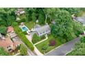 Aerial view of a beautiful home with a pool, lush landscaping, and mature trees, offering a private retreat at 6745 Wheeler Dr, Charlotte, NC 28211