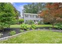 Landscaped front yard featuring a lush lawn and decorative rock borders, adding to the home's curb appeal at 6745 Wheeler Dr, Charlotte, NC 28211