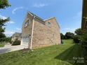 Side view of a two story brick home with a well maintained lawn at 707 Five Leaf Ln, Waxhaw, NC 28173