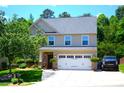 Charming two-story home with a two-car garage, lush landscaping, and a well-manicured lawn at 7170 Kenyon Dr, Denver, NC 28037