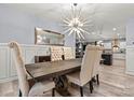 Formal dining room features a modern chandelier and views into the open concept kitchen at 7809 Creek Park Dr, Denver, NC 28037