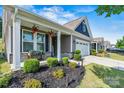 Inviting front porch with manicured landscaping and stone accents adding curb appeal at 7809 Creek Park Dr, Denver, NC 28037