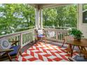 Inviting outdoor balcony with comfortable seating, colorful rug, and views of lush greenery at 915 Northeast Dr # 15, Davidson, NC 28036