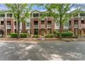 Brick townhome with balconies and mature trees creating a serene street view at 915 Northeast Dr # 15, Davidson, NC 28036
