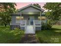 Charming home featuring a quaint porch, light gray siding, complemented by a well-maintained lawn and mature trees at 935 Church St, Kings Mountain, NC 28086