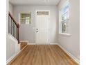 Bright entryway with wood floors, white door, and staircase at 9630 Turning Wheel Dr, Charlotte, NC 28214