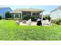 Backyard boasts a stone patio with a built-in fire pit, perfect for outdoor gatherings at 11324 Fullerton Place Nw Dr, Huntersville, NC 28078