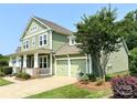 A quaint home featuring a convenient two-car garage and well-manicured landscaping at 11324 Fullerton Place Nw Dr, Huntersville, NC 28078
