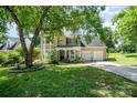 Inviting tan two-story home boasting a well-maintained lawn, two-car garage, and blooming flower beds at 11802 Fox Glen Rd, Charlotte, NC 28269