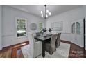 Stylish dining room with a decorative light fixture, large windows, and classic wainscoting at 1201 Beckford Glen Dr, Waxhaw, NC 28173