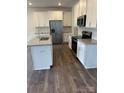 Modern kitchen featuring white cabinets, stainless steel appliances, and a center island at 15208 Caspian Way, Charlotte, NC 28278