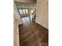 Open-concept living room showcasing hardwood floors, large windows, and white trim at 15208 Caspian Way, Charlotte, NC 28278
