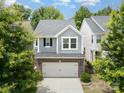 A two-story home with gray siding, complemented by a brick-clad two-car garage and a concrete driveway at 15524 Scholastic Dr, Charlotte, NC 28277