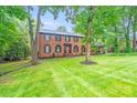 Beautiful brick home featuring well-maintained landscaping, a vibrant lawn, and a classic, timeless design at 16512 Kimbolten Dr, Huntersville, NC 28078