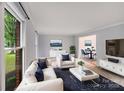 Bright, modern living room with white furniture, a large window, and an open concept layout for easy entertaining at 16512 Kimbolten Dr, Huntersville, NC 28078