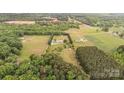 High-angle aerial shot capturing the property's size, surrounding trees, outbuildings and its position in the landscape at 1720 Lowe Dr, Catawba, NC 28609