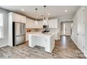 Bright, open kitchen with a large island, stainless steel appliances, and stylish white cabinets at 173 Morgans Branch Rd, Belmont, NC 28012